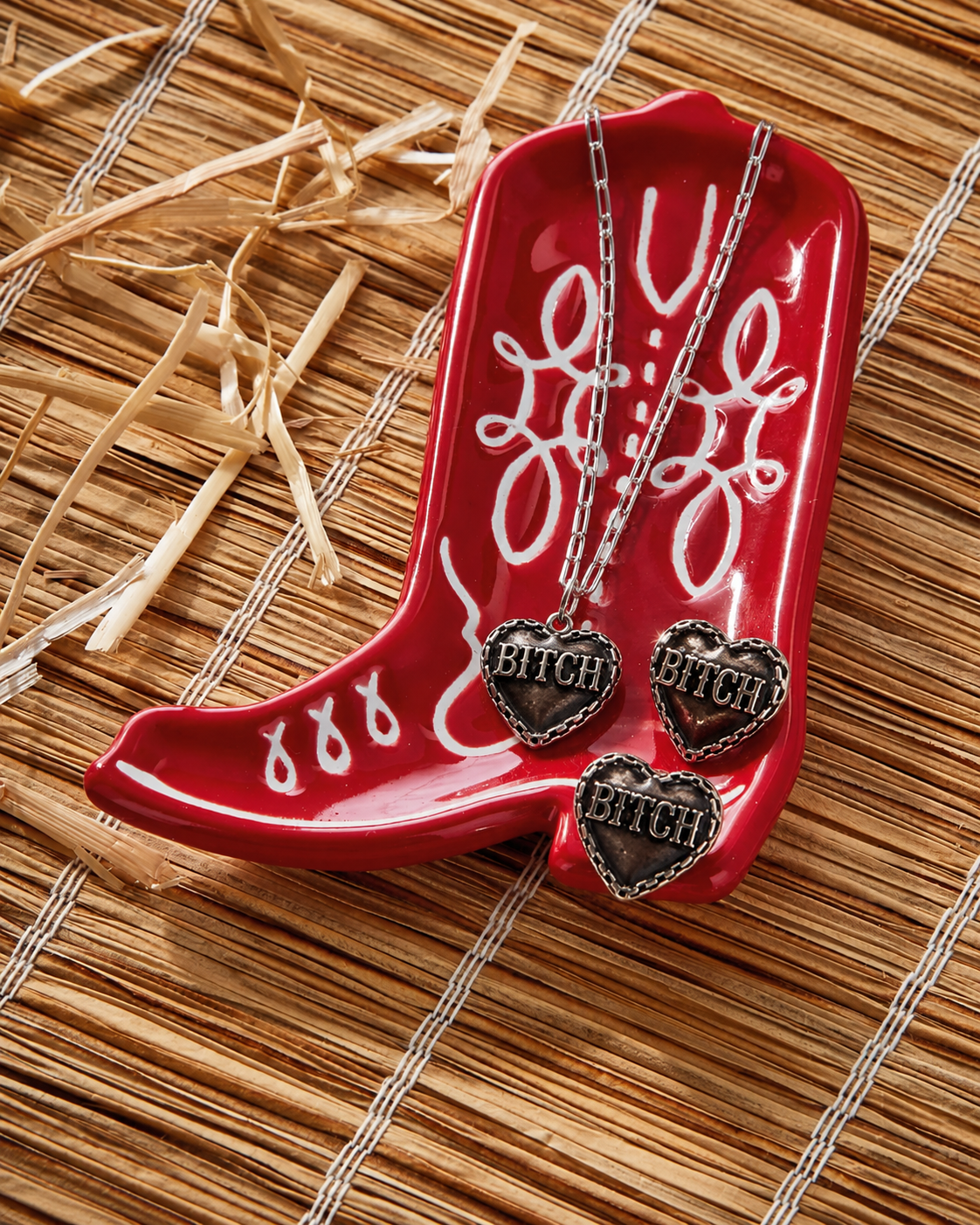 Red boot-shaped dish with necklaces on a straw background