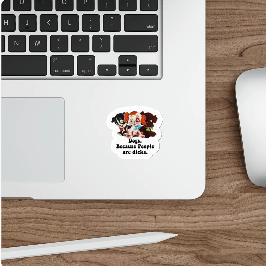 A die-cut sticker featuring cartoon characters and the text 'Dogs. Because People are dicks.