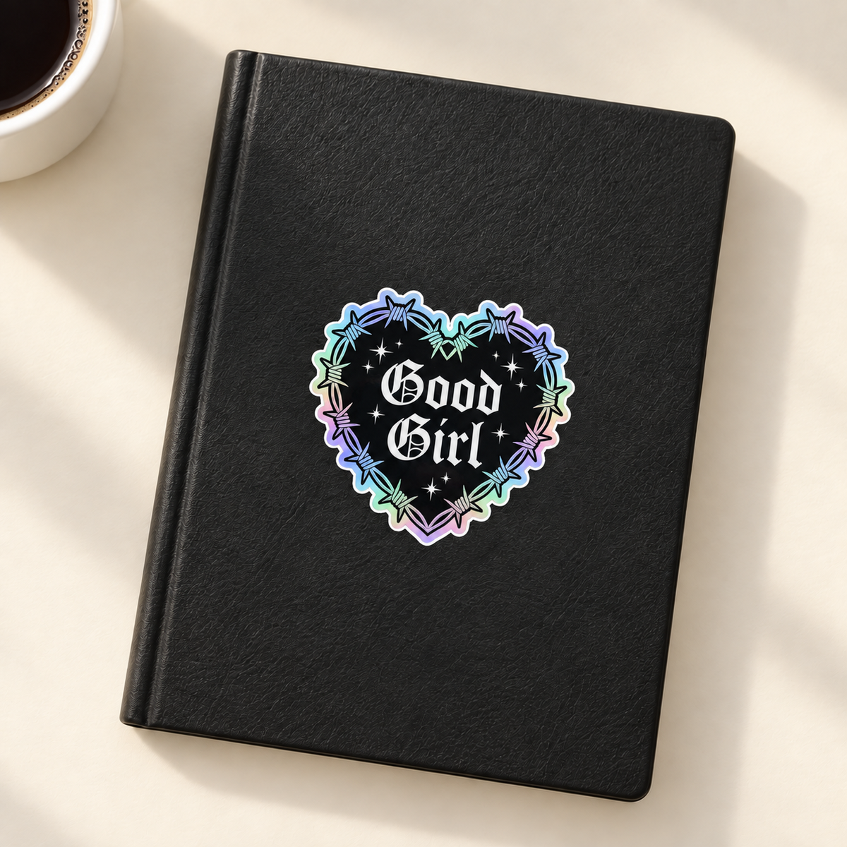 Good Girl holographic heart sticker on black notebook
