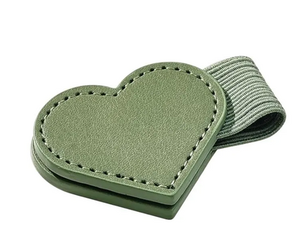 An olive green heart-shaped leather luggage tag with a matching elastic strap, shown on a plain white background.