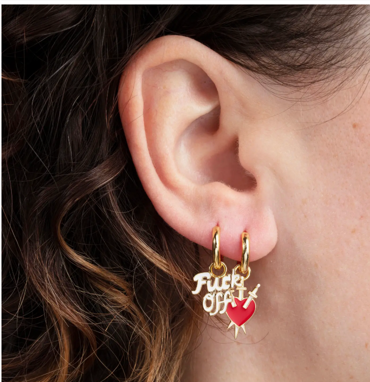 Mismatched gold hoop earrings worn together on one ear