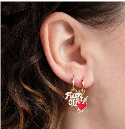 Mismatched gold hoop earrings worn together on one ear